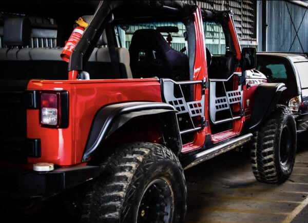 Red Jeep JK Wrangler Unlimited, modified with lift, flares, tube doors, roof removed